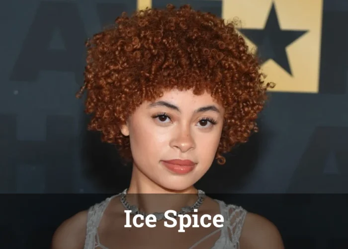 Ice Spice performing live on stage, wearing a stylish outfit and engaging with an excited audience.