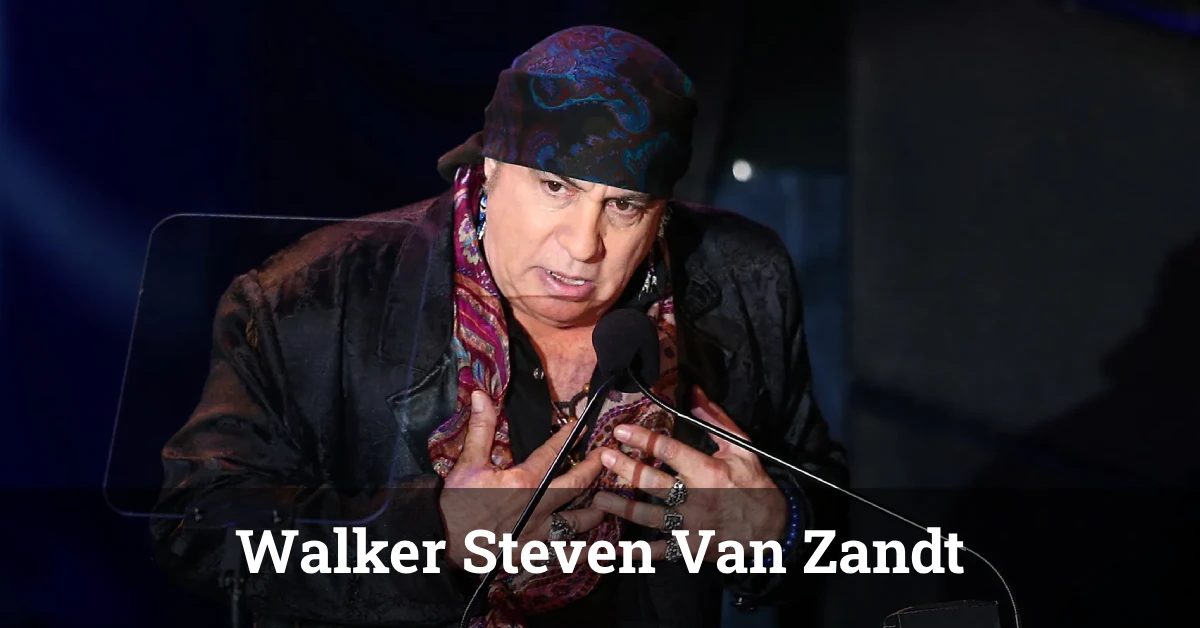 Walker Steven Van Zandt performing live on stage with a guitar, wearing a leather jacket under colorful stage lights.