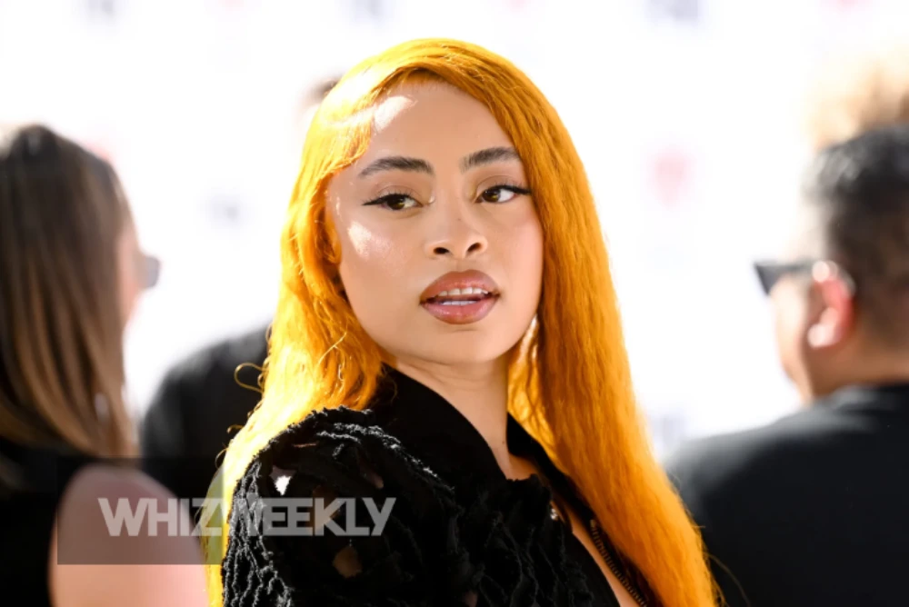 Ice Spice Net Worth and his performing on stage, with her signature ginger hair and a microphone.