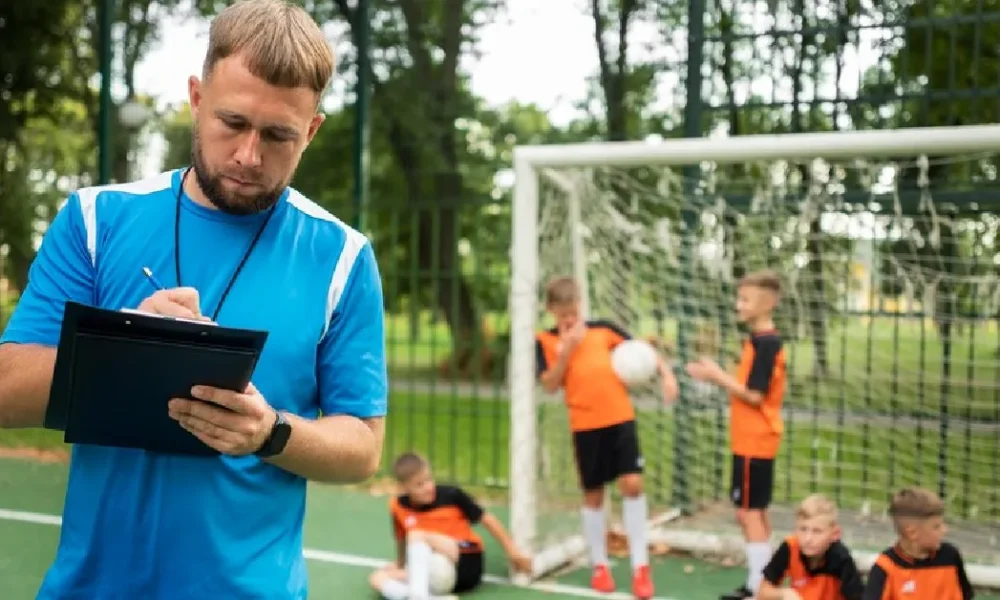 Unlocking Excellence: A Comprehensive Guide to the Keeper Standards Test Soccer coach evaluating youth goalkeepers during Keeper Standards Test training session