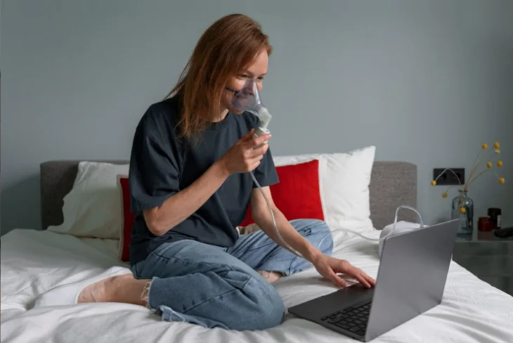 Person using inhaler to cope with respiratory issues, demonstrating proper technique for managing breathing difficulties.