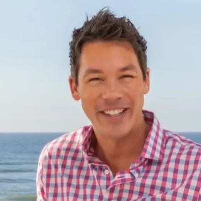 David Bromstad smiling at the beach showcasing his vibrant personality that matches his bold design philosophy and colorful aesthetic on HGTVRetryClaude can make mistakes. Please double-check responses.