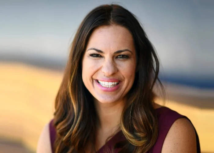 Jessica Mendoza smiling confidently in purple attire, representing her transition from Olympic softball champion to pioneering ESPN baseball analyst breaking gender barriers.