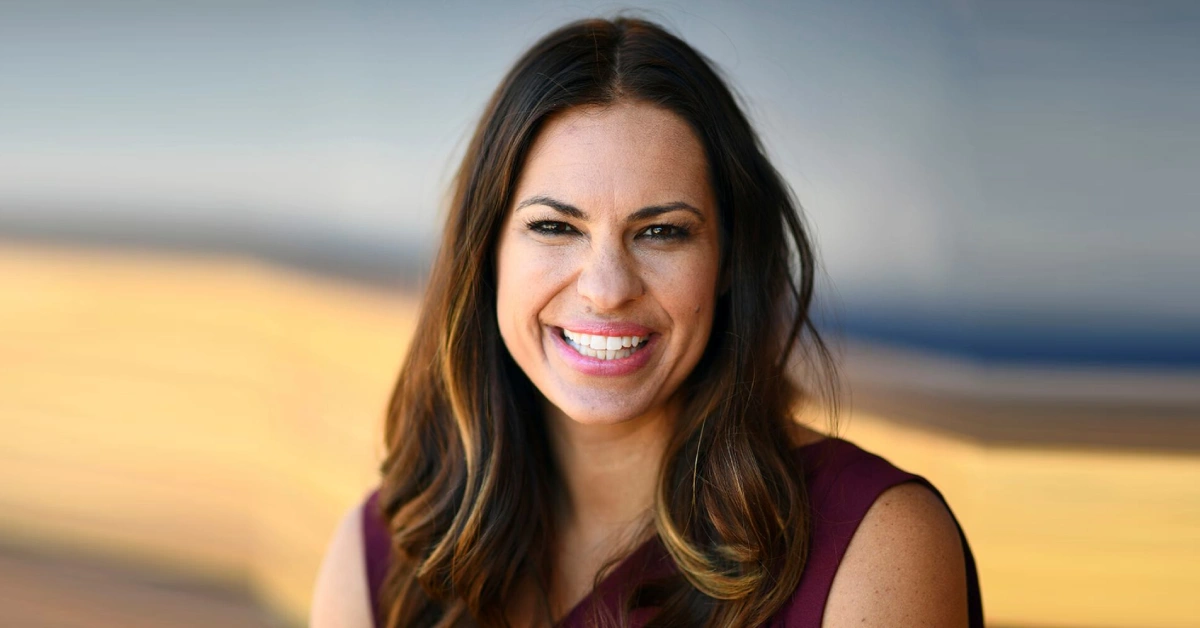 Jessica Mendoza smiling confidently in purple attire, representing her transition from Olympic softball champion to pioneering ESPN baseball analyst breaking gender barriers.