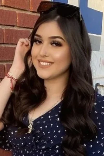 Melody Aguilar smiling confidently in a navy polka dot dress, showcasing the authentic personality that's made her a trusted social media influencer